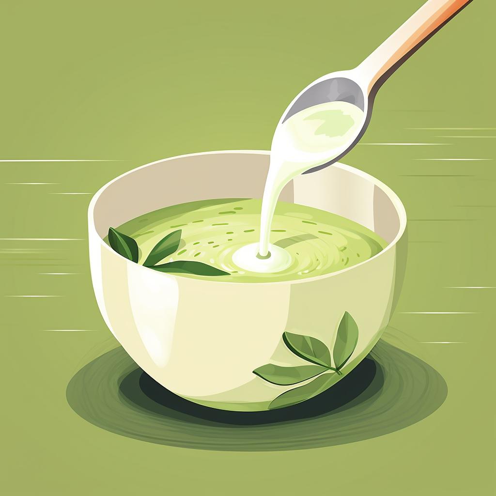 Warm milk being poured into a bowl of matcha mixture.